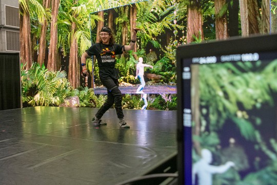 a student dancing in front of a monitor which shows real time motion capture.