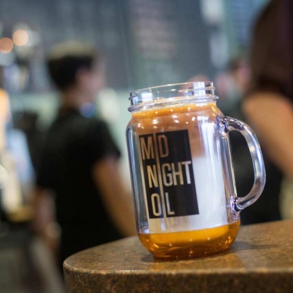 A midnight oil masonry glass mug sitting on a countertop