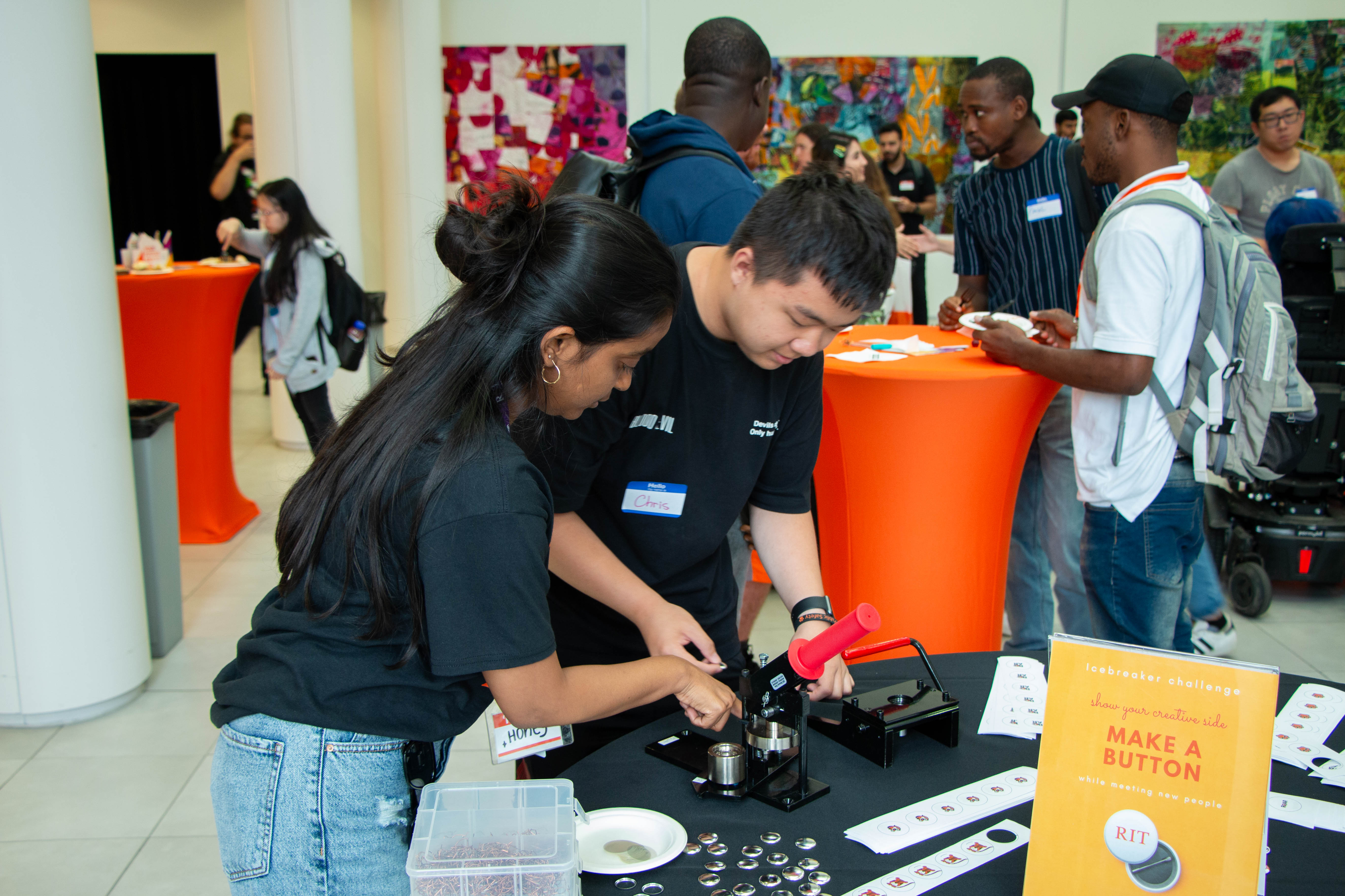 two students on the button making table making a pin