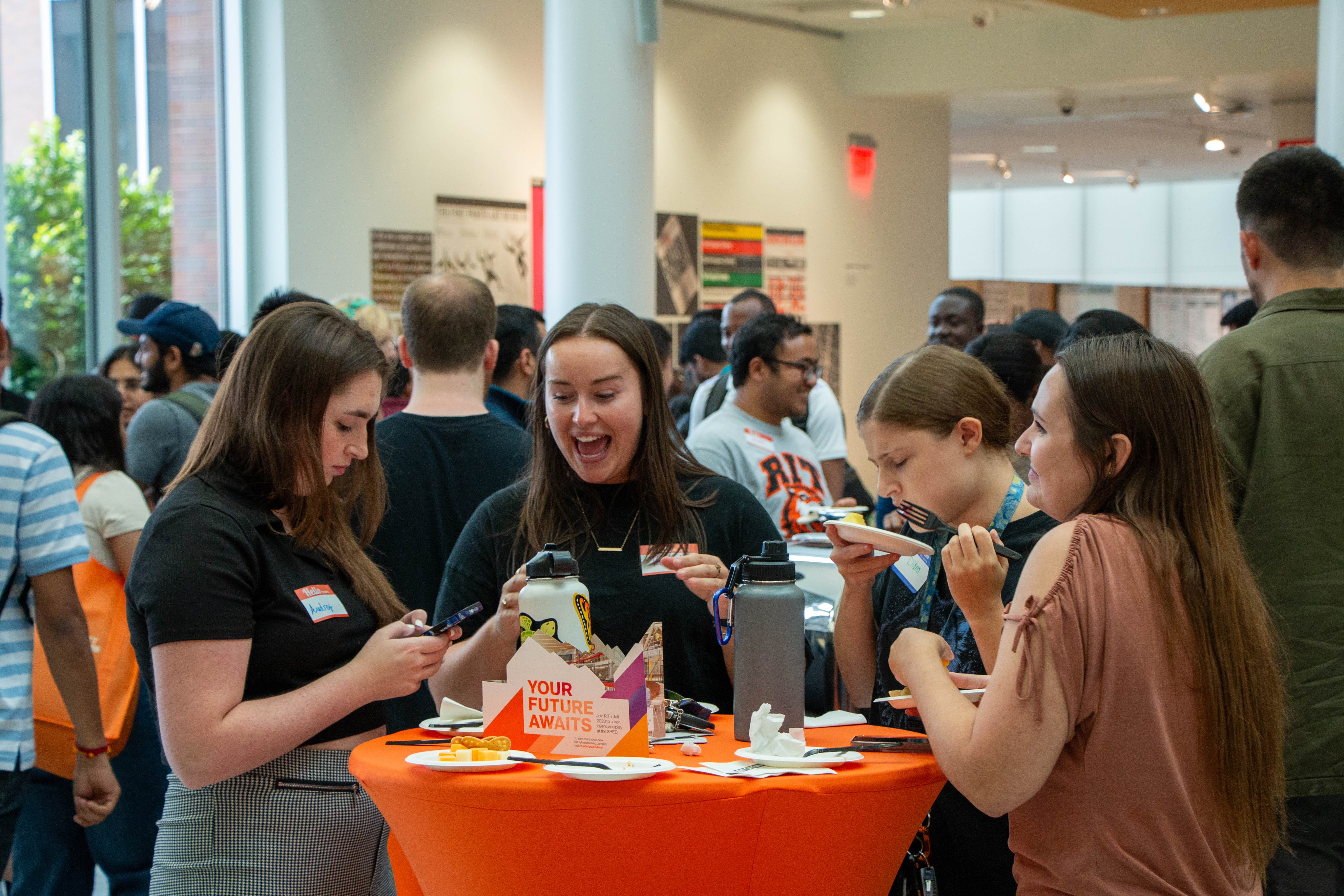 students standing around a table enjoying snacks as they mingle