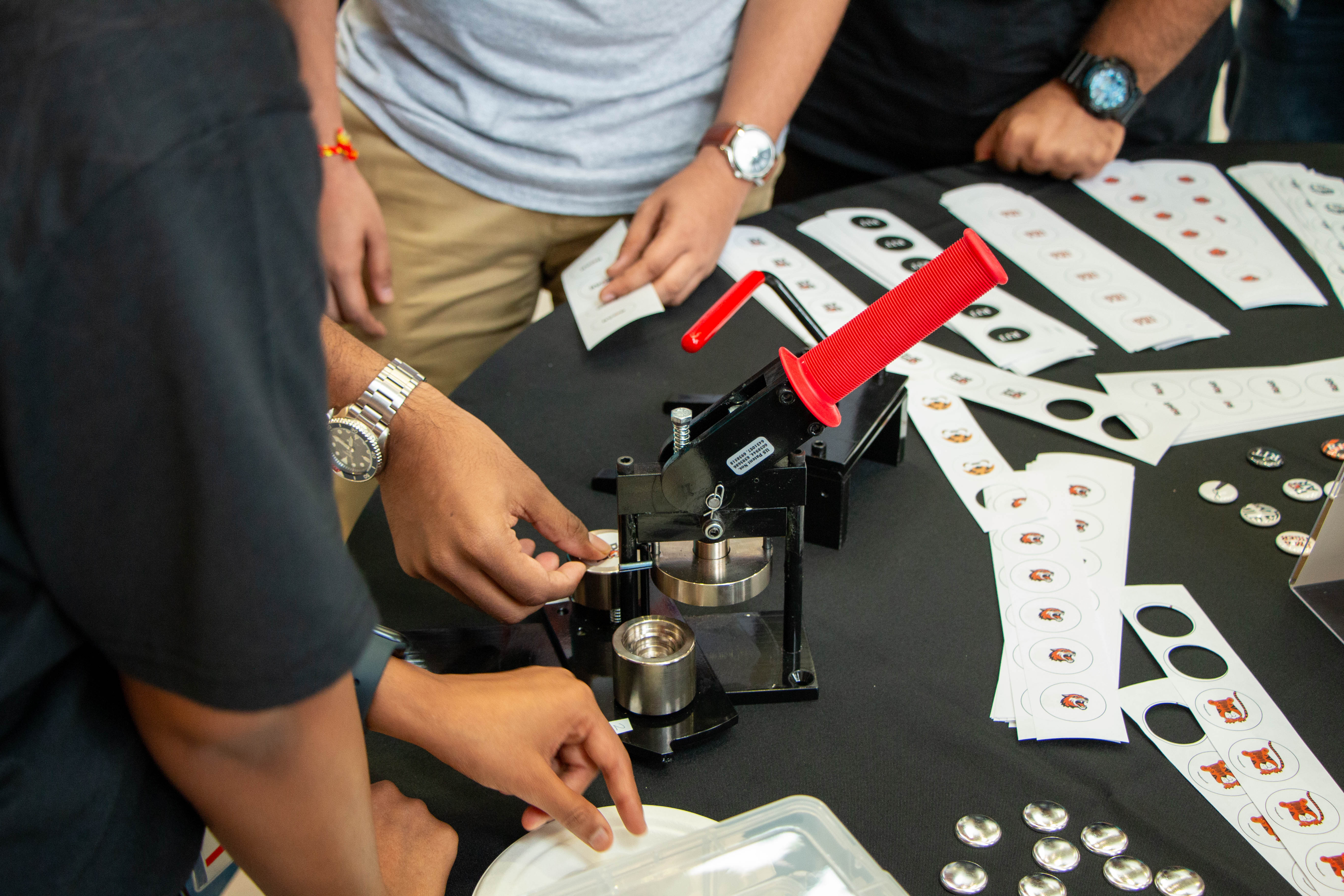 the button making machine putting the rit tigers in the machine