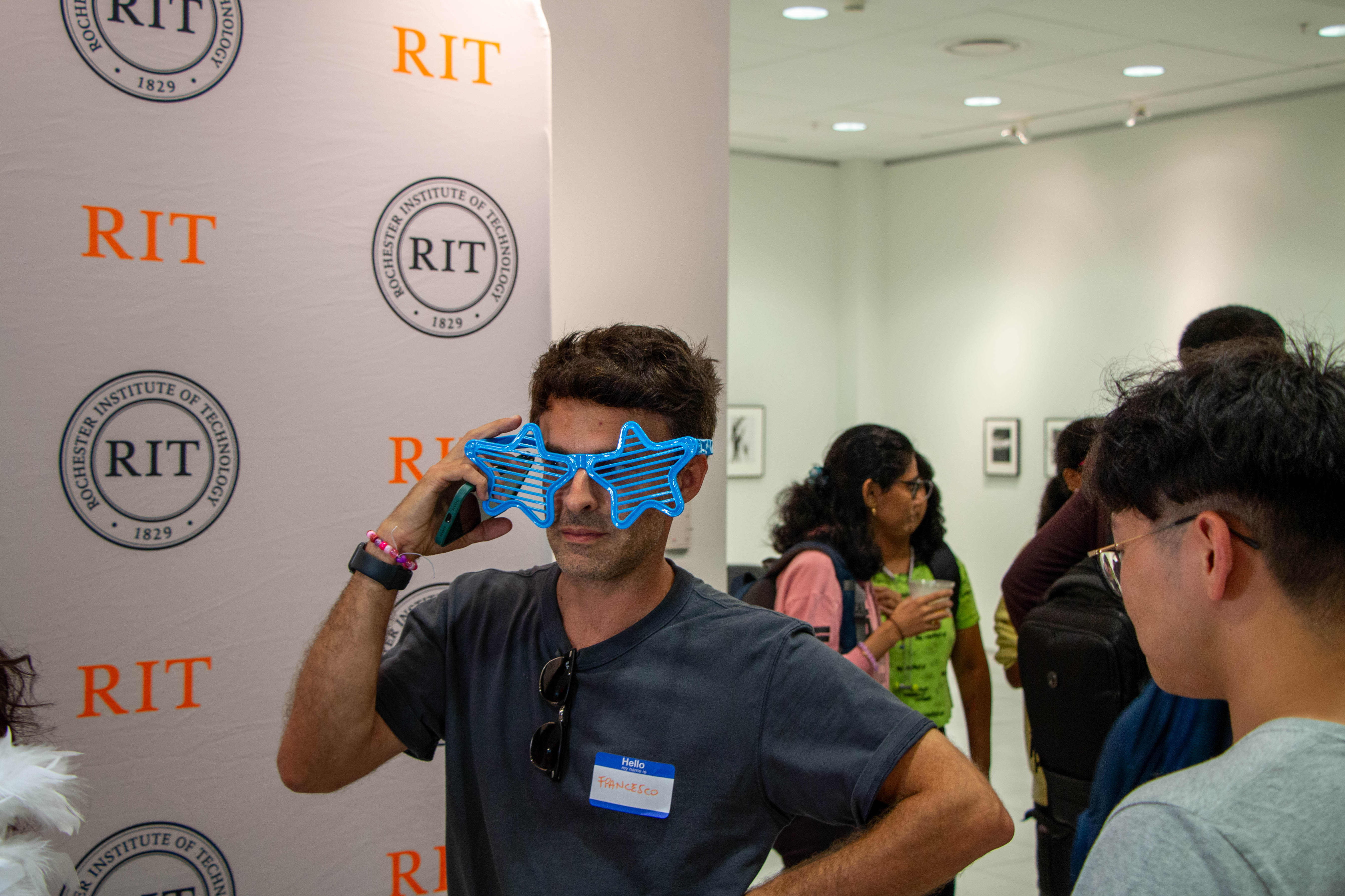 student wearing blue prop glasses while posing for a photo