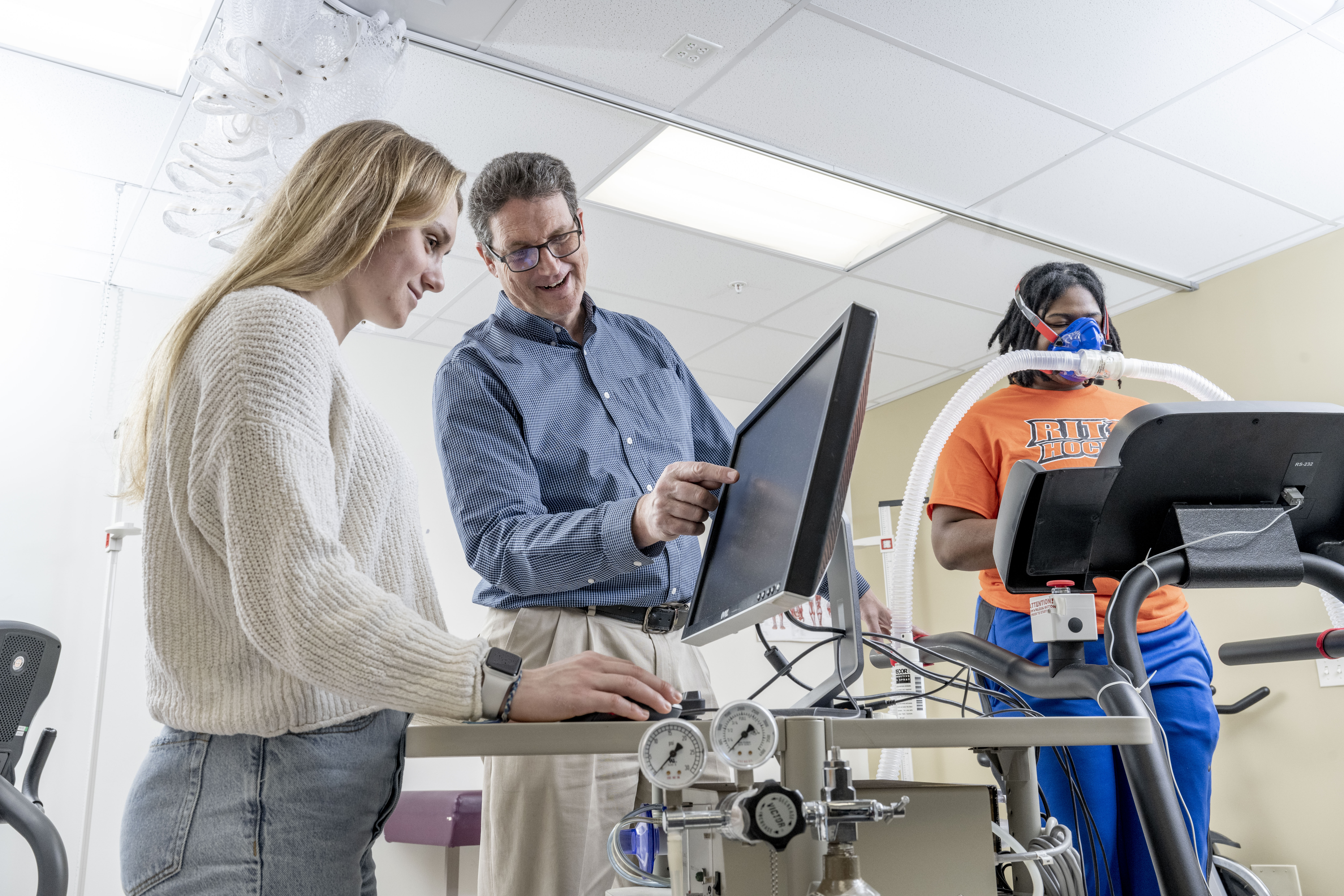 Professor pointing to computer screen while students are running a metabolic assessment