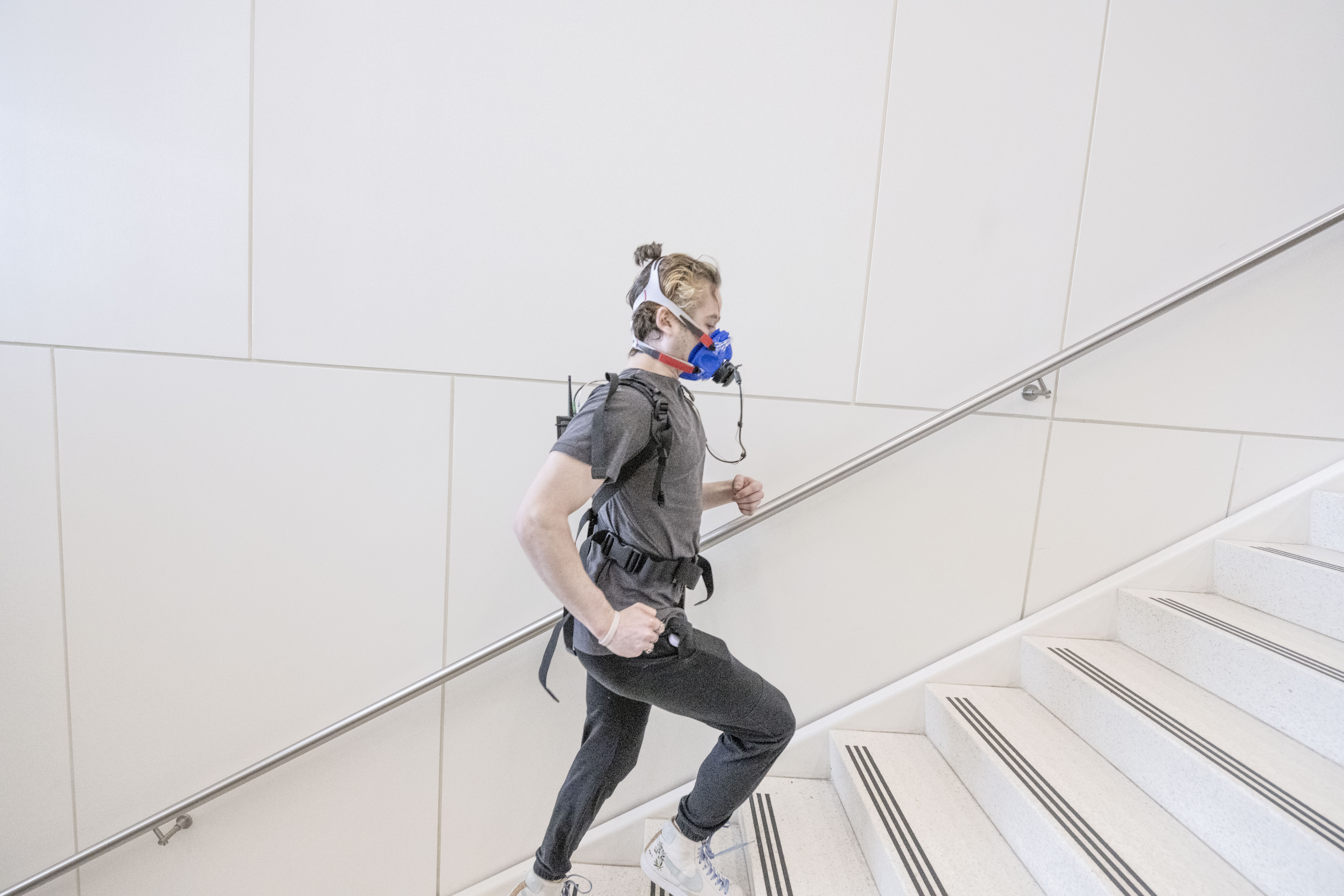 Individual running up stairs while wearing a mobile VO2 Max system & mask