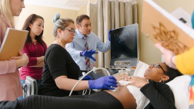 A group of people performing a sonogram on a patient