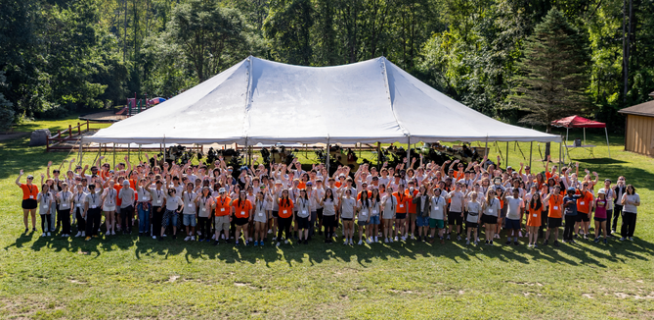 Overhead Shot of all students and mentors gathered at Honors Orientation at Camp Arrowhead infront of a large white tent