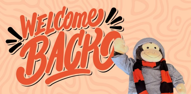 Image of Stanley waving with background text that says "Welcome Back"