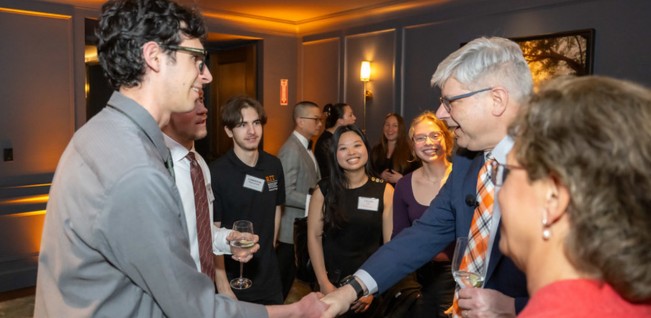 Image of President Sanders shaking hands with an Honors Student on the Honors Boston Spring Break Trip