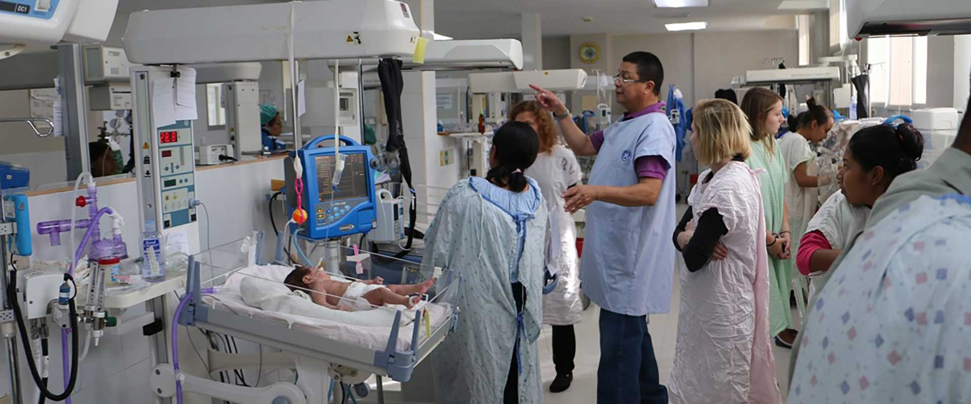 professor and students tour Honduran hospital's Nic-U unit with a doctor.