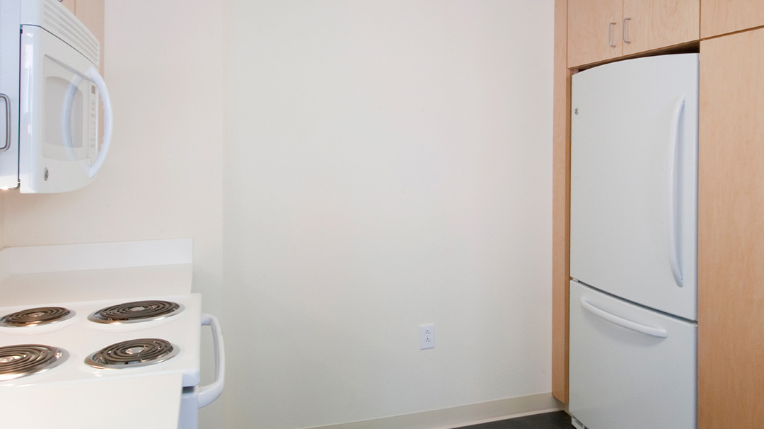 view of suite kitchen showing stove, microwave, and refrigerator