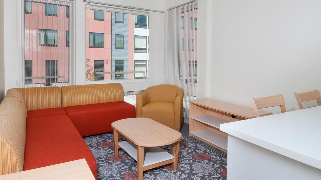 living room in suite showing a couch, chair, coffee table, credenza, and counter chairs