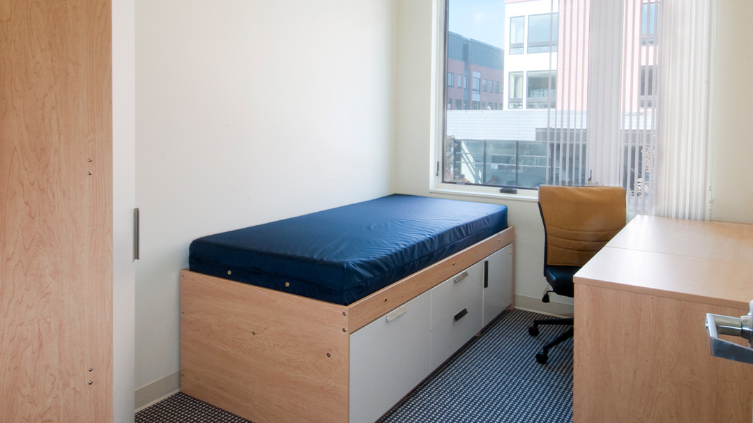 single bedroom with a storage bed, desk, desk, and chair