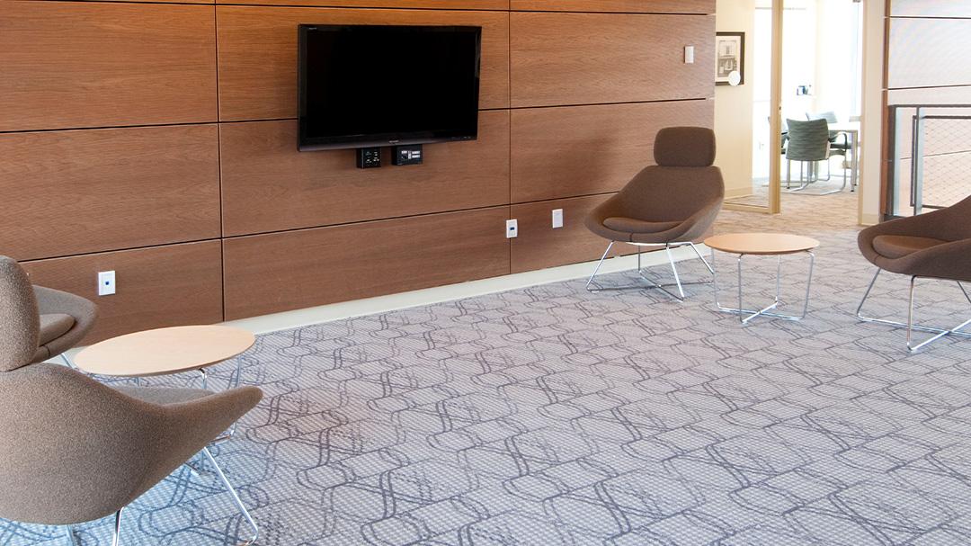 lobby of building with wood wall, tv and chairs