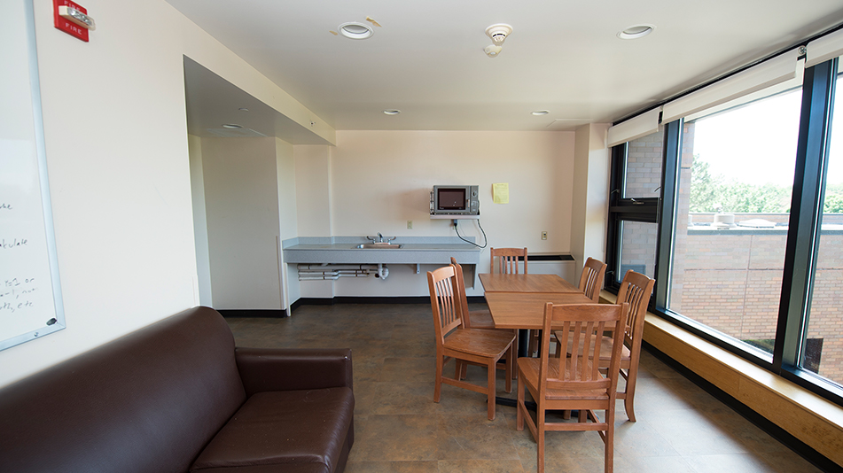 shared lounge with a couch, table, sink, and microwave