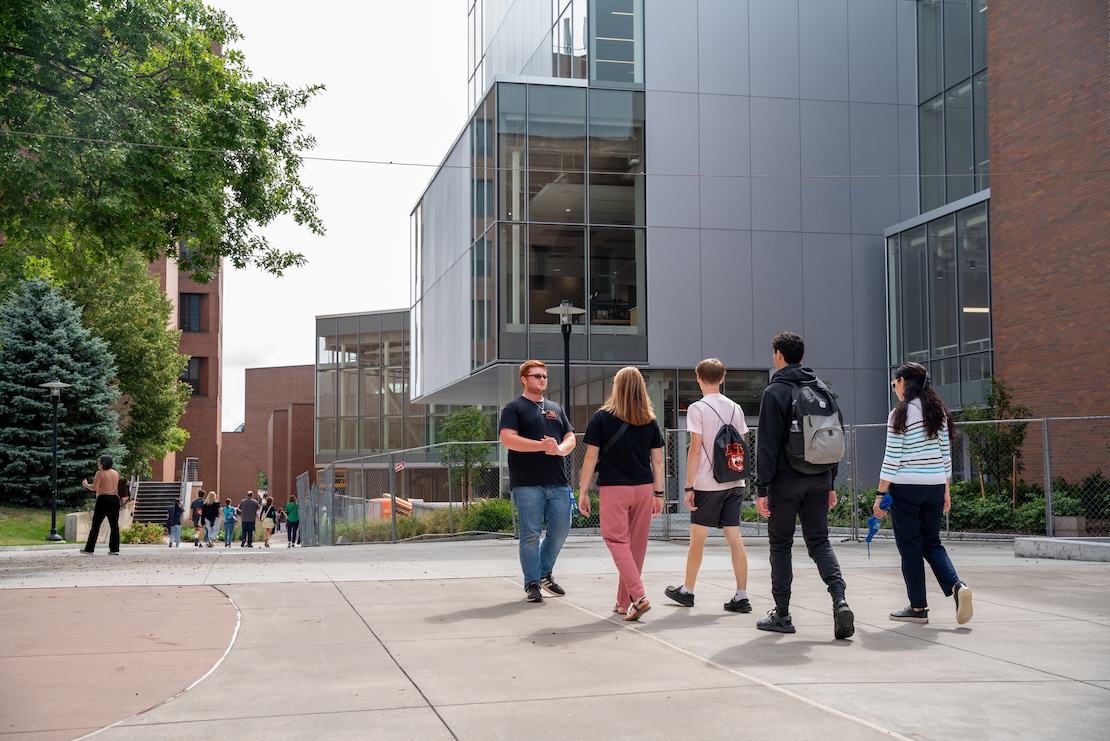 student giving a campus tour and the family's back facing the camera