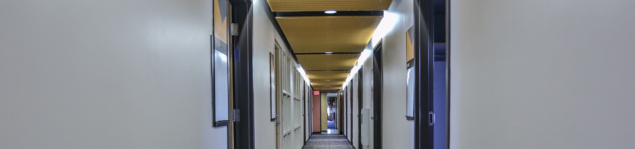 hallway of residence hall with gray wayy and wood ceiling
