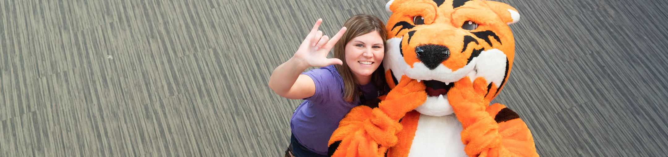 Ritchie and student making the i love you sign in ASL