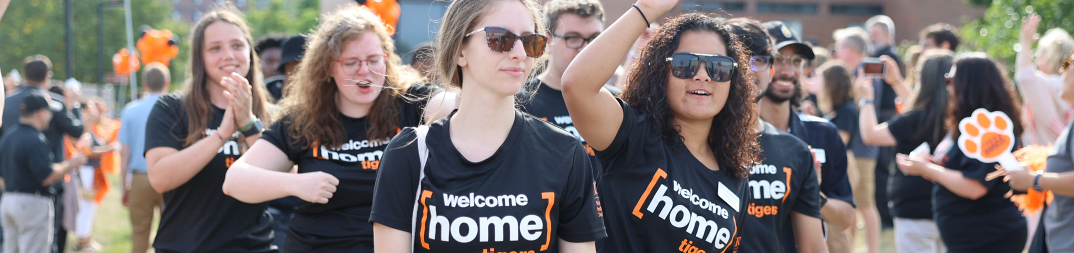 students in black shirts that say HOME walking outside