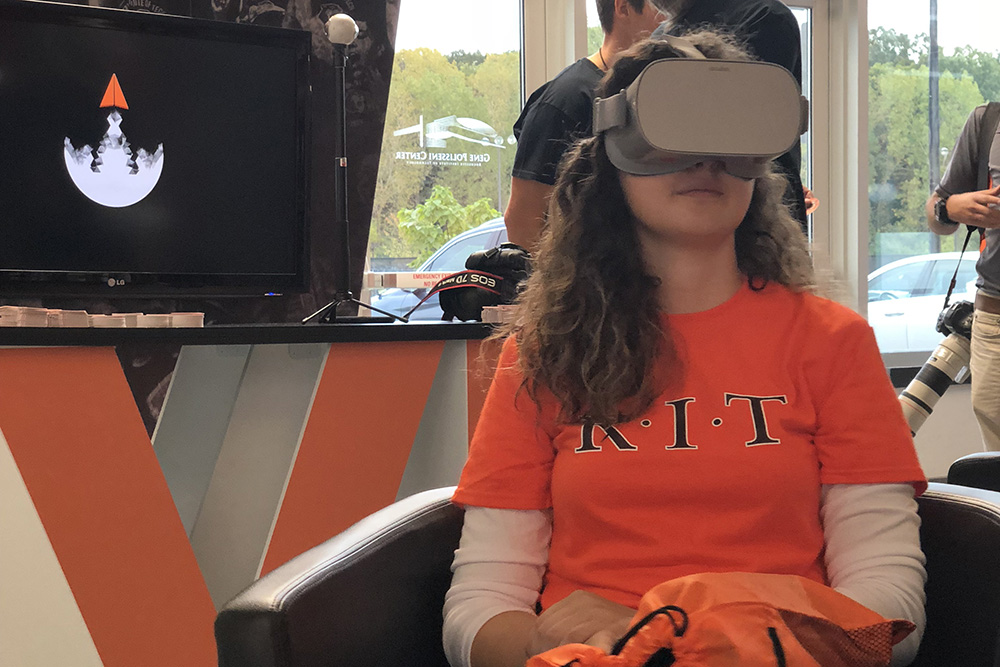 girl sits in chair wearing a virtual reality headset