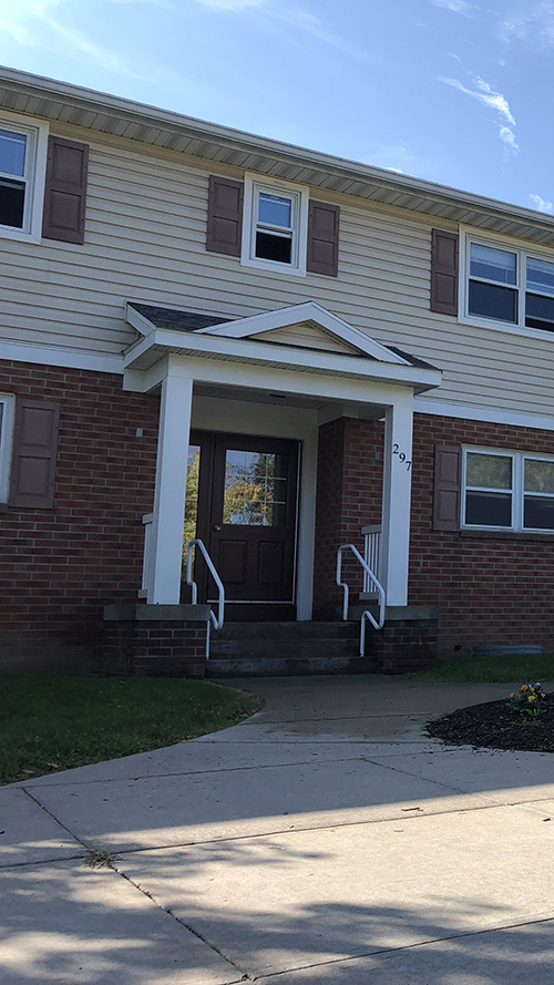 two story brick and cream siding apartment building entrance
