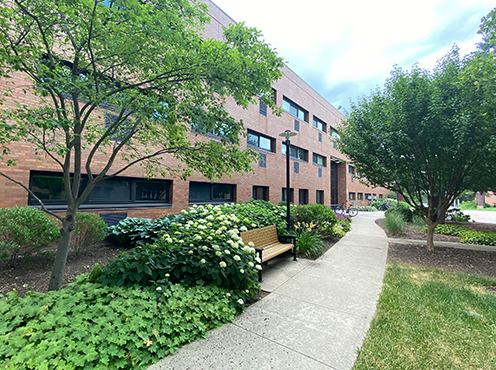 three story brick building with landscaping in front
