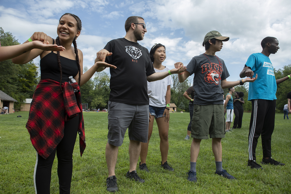 Students stand in a line with a Resident Advisor