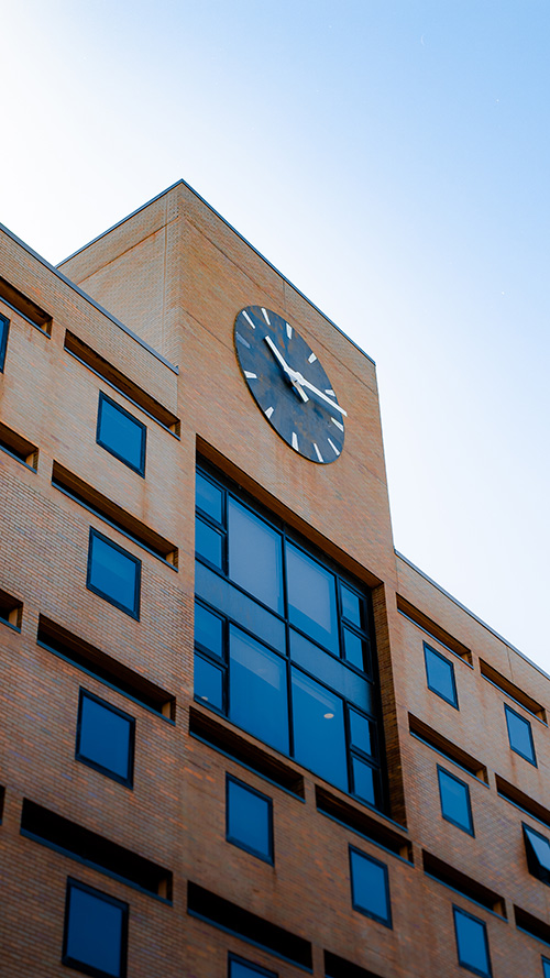brick high rise building with a clock at the top