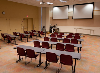 Empty room with tables and chairs set at the Student Development Center