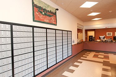 hallway with post office boxes and a counter at the end