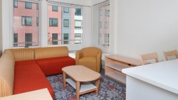 living room in suite showing a couch, chair, coffee table, credenza, and counter chairs