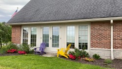 exterior of Greek Circle brick residence with Adirondack chairs outside