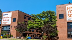 Exterior of Residence Halls A and B with banners reading "Home of Thinkers, Makers, Doers" and "Find Your Squad"