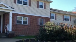 exterior of two floor building, Perkins Green. brick on the bottom and yellow siding on top