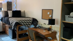 twin bed with a comforter, desk, and cubbies