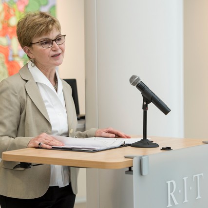 dean speaking at podium.