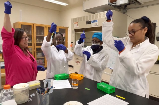 Three Rochester Prep students work with Dr. Lea Michel in her lab at RIT