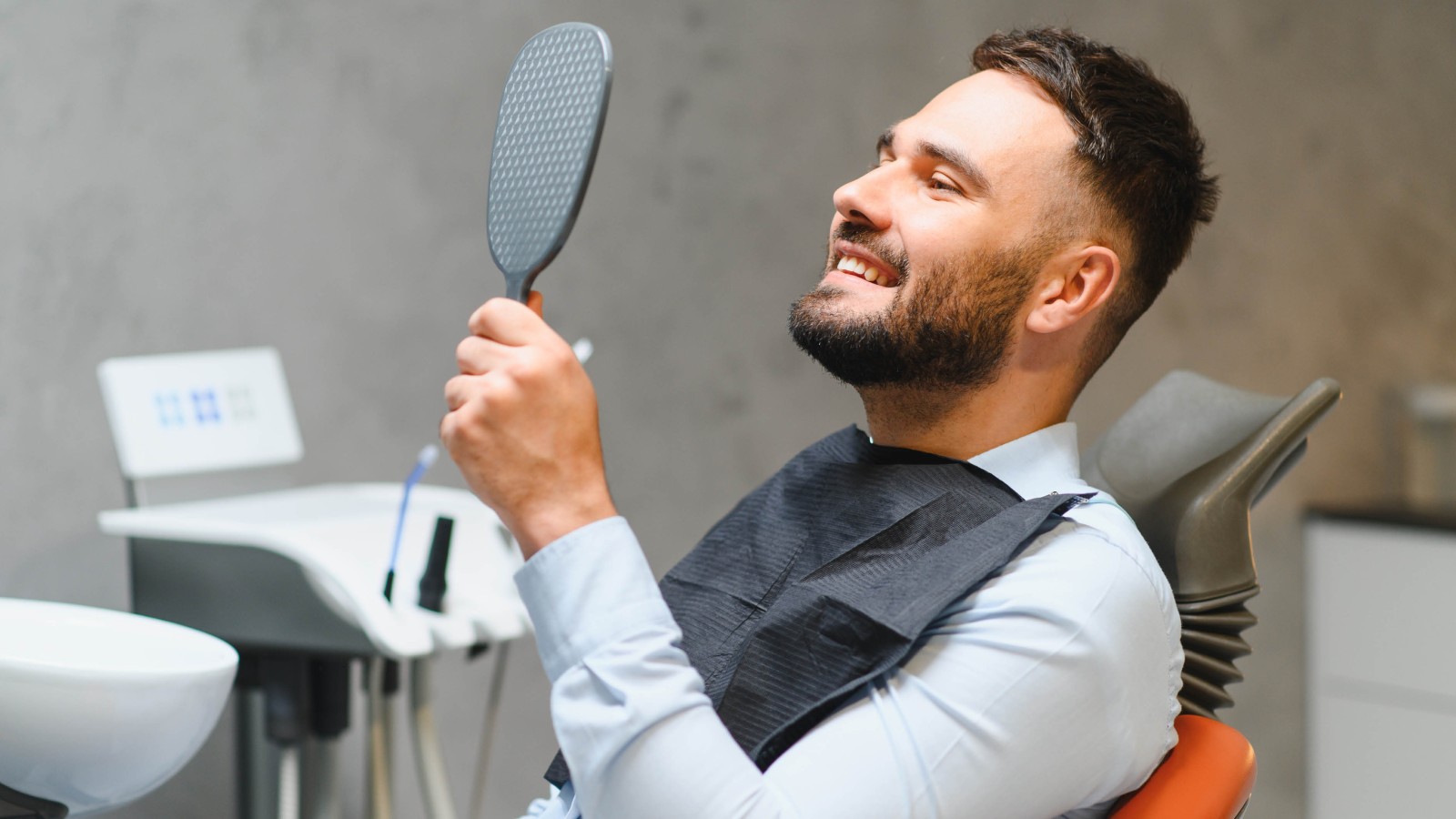 men looking in mirror at dental office
