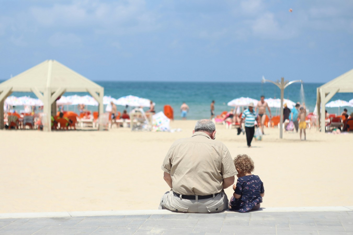 grandparent and child sitting together watching the beach in the background