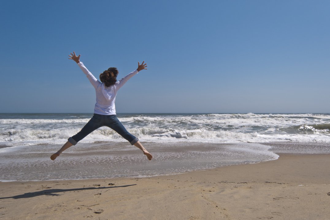 Woman jumping near the ocean