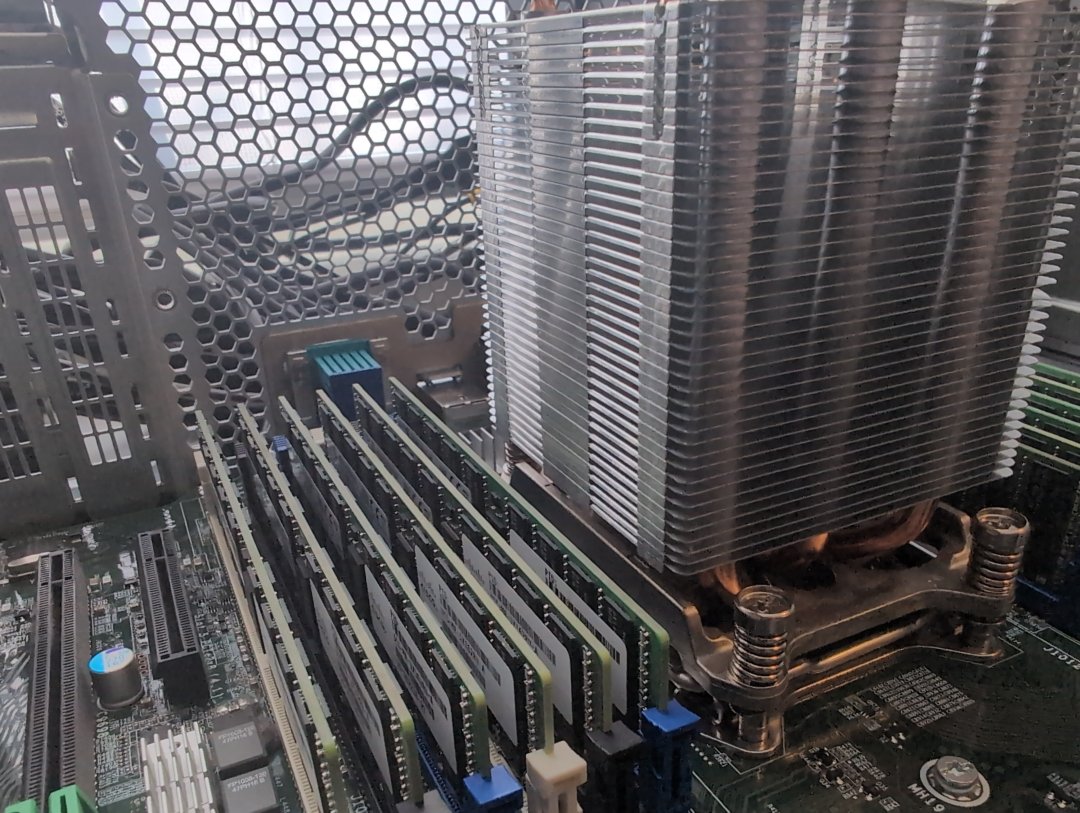 Image of a Computer motherboard with CPU Heat Sync and Memory visible as green colored printed circuit boards and aluminum copper heat sync