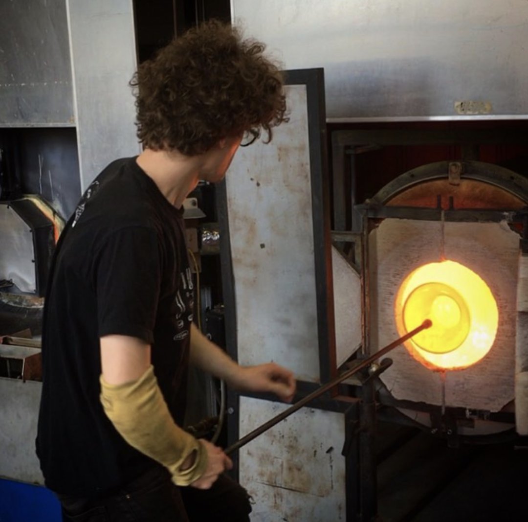 A student blowing glass