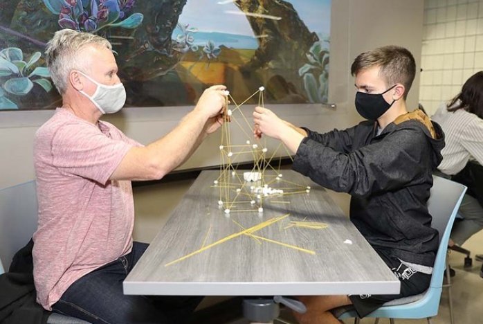 Guests building a tower out of spaghetti and marshmallows