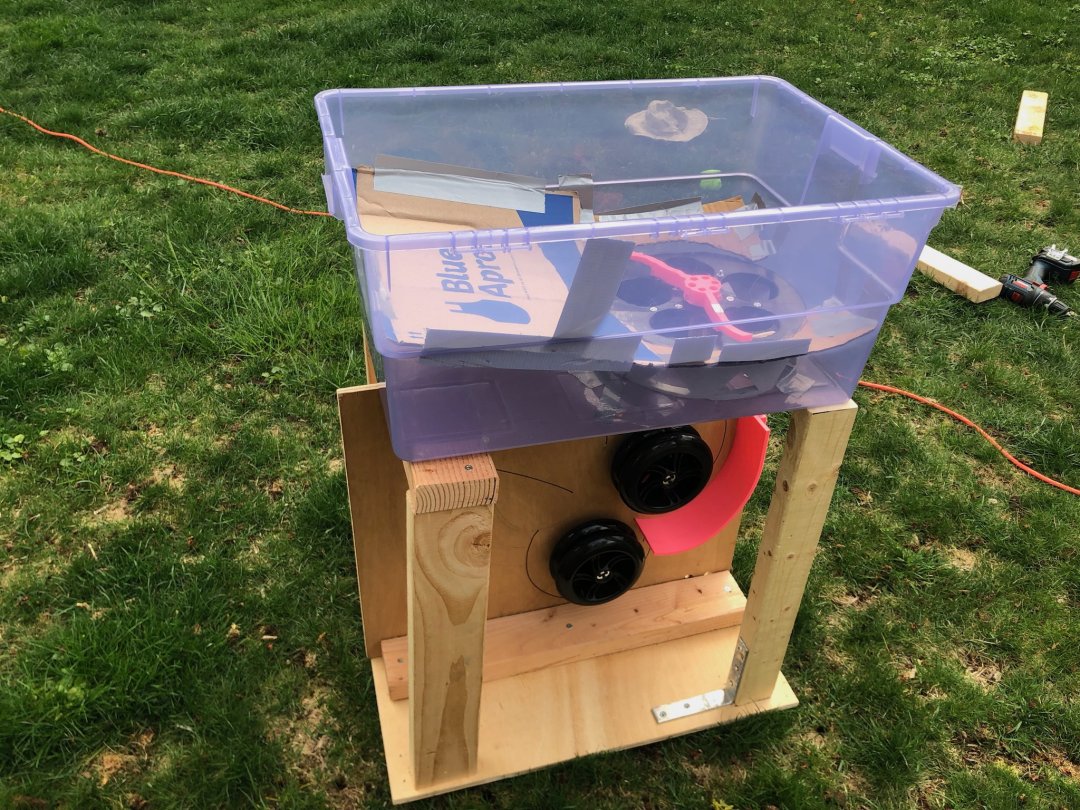 An image of a wooden prototype of a tennis ball machine