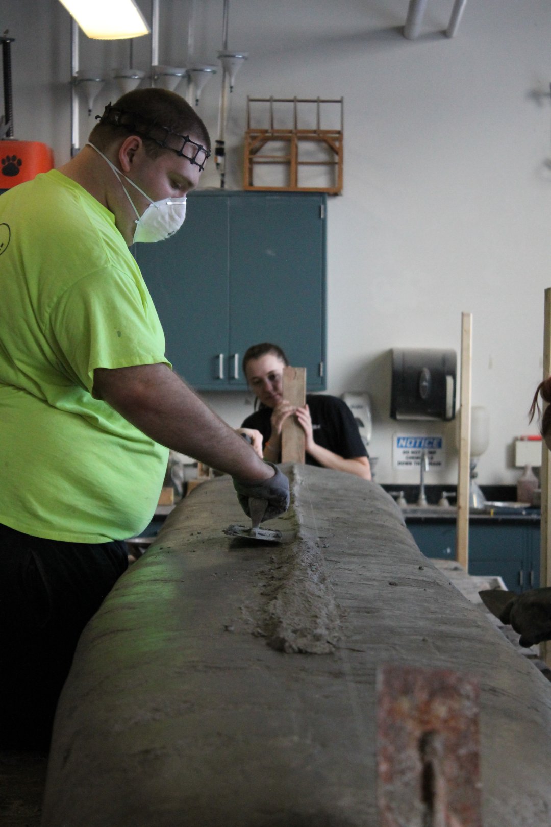 A person troweling the keel of the canoe.