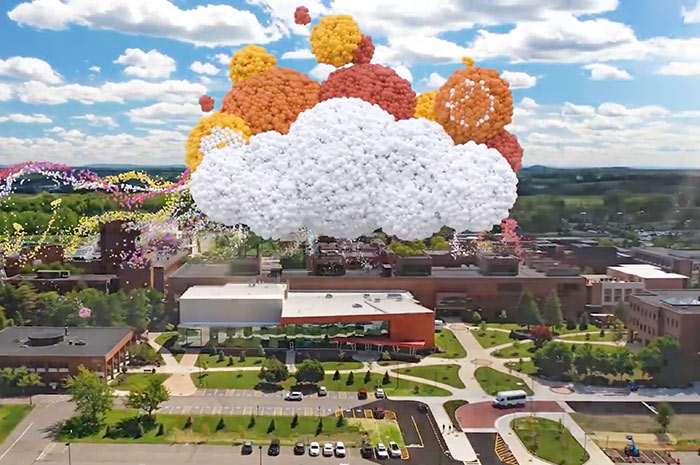 Aerial view of buildings on campus with the Imagine RIT logo forming out of many colored balloons.