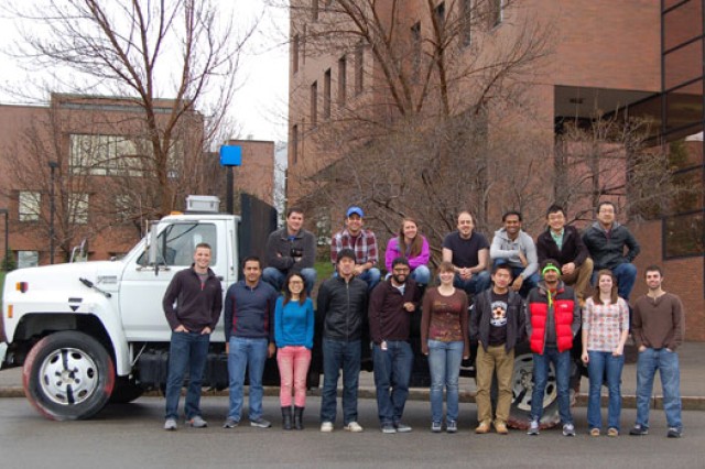 People posing for camera outside classroom buildings
