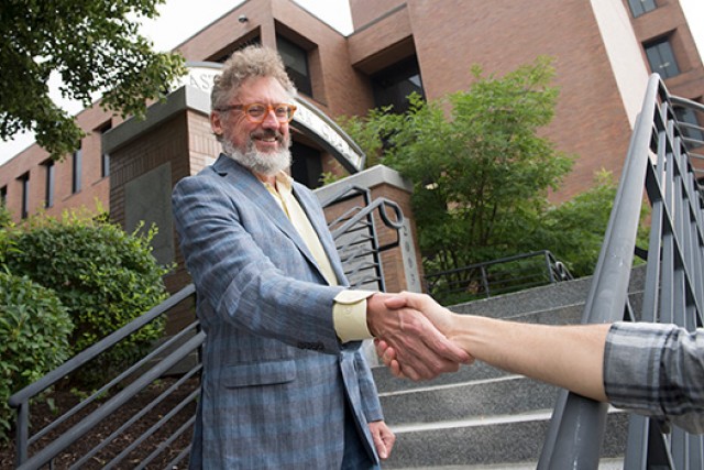 Two men shake hands.