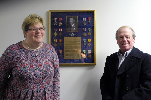 man and woman standing next to display of military medals.