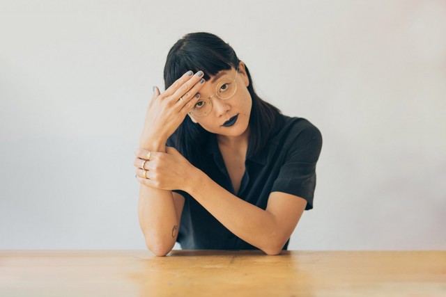 Christine Sun Kim sitting at a table.