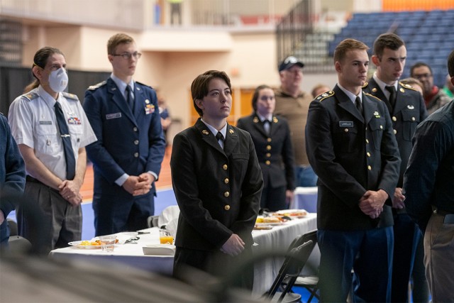 members of the various branches of the U.S. military standing during a breakfast.
